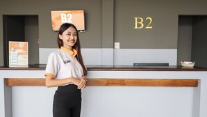 A reception desk with a sign reading "B2" and a digital screen above it. - B2 Lanna Boutique & Budget Hotel (Chiang Mai)