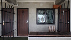 A modern entrance with a wooden door, a window with curtains, and a metal gate. - B2 Lanna Boutique & Budget Hotel (Chiang Mai)