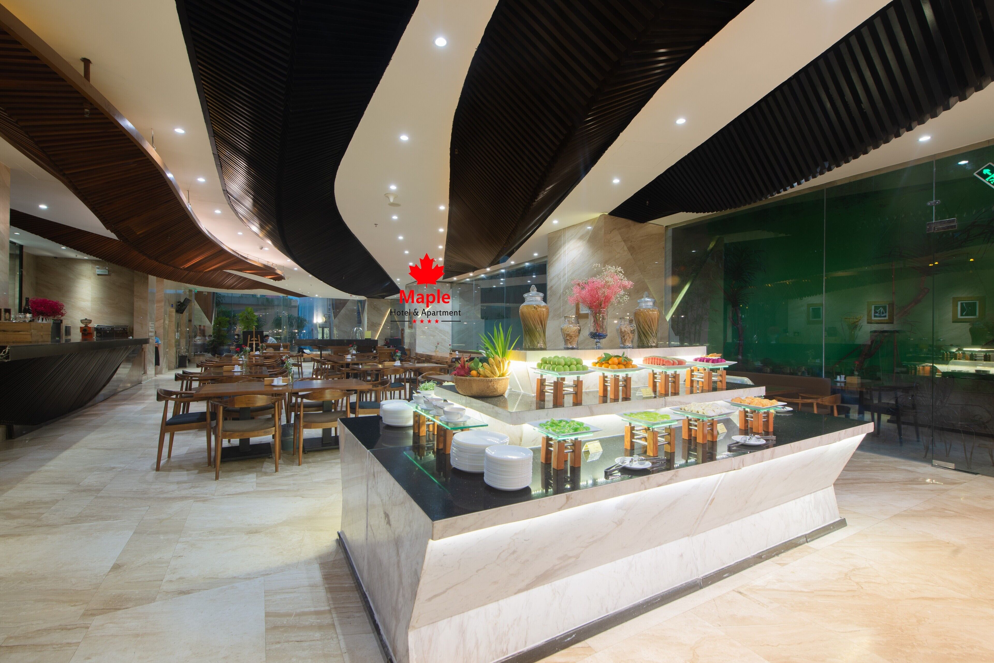 Zona de recepción del Hotel & Apartamentos Maple con mesa de buffet, sillas de madera y un diseño de techo moderno.