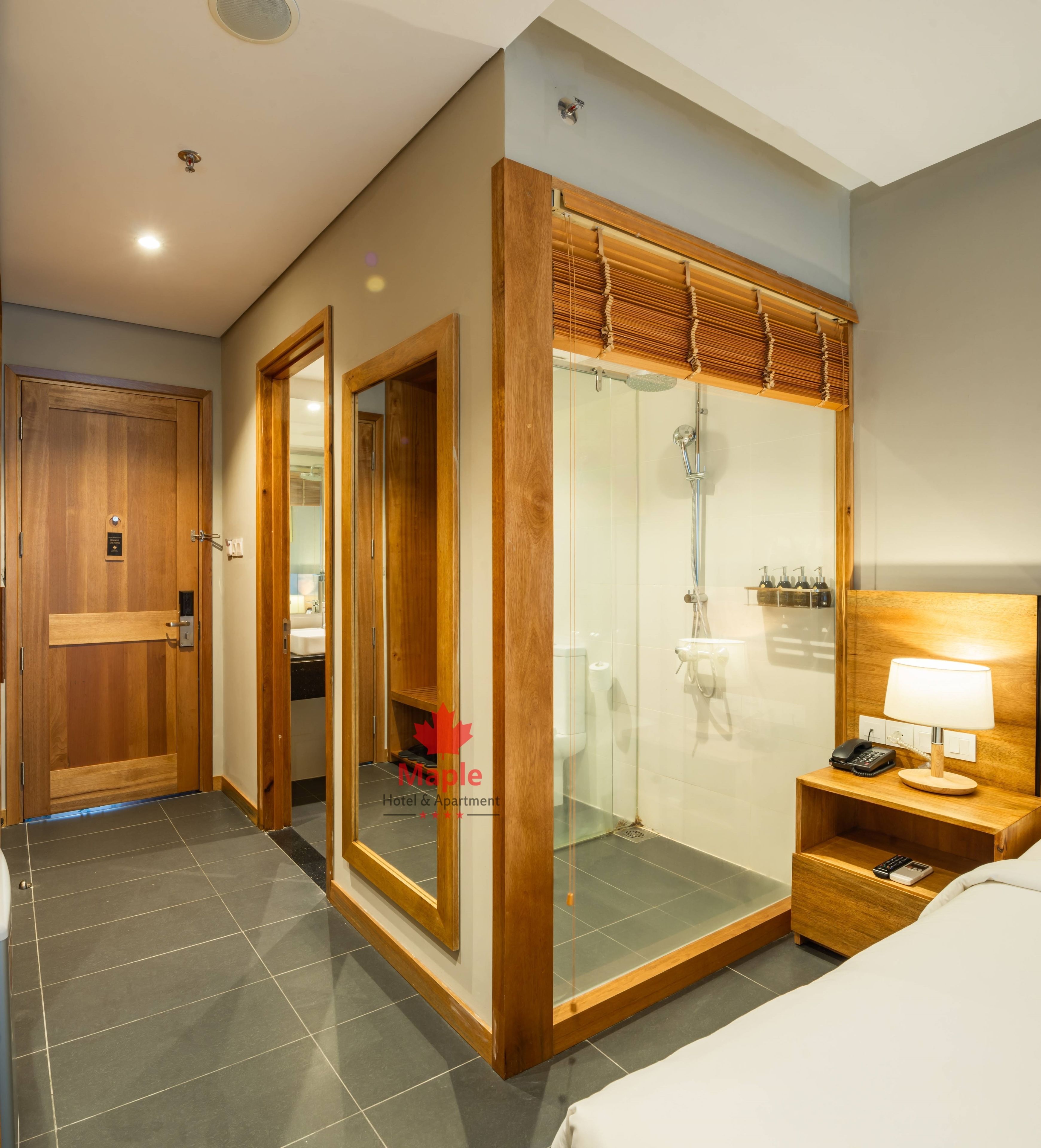 A modern bathroom with a glass shower enclosure, wooden doors, and a visible toilet.