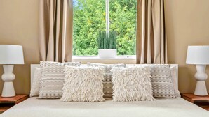 A bedroom with a large bed, two bedside lamps, a window with curtains, and a potted plant. - 🪷Lotus House-Relaxation-few Minutes to🏖️ Beaches-🏊Heated Pool (Venice)