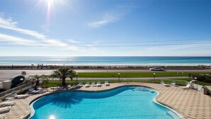 A swimming pool with a view of the ocean and a road with vehicles. - NewBestChoice🌴2pools,1Hot, Internet,Tennis🌞BeachSvc,2 Chair,1 Umbrella,Sleep 6 (Miramar Beach)