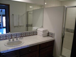 Een bad/douchecombinatie, een haardroger, handdoeken, zeep