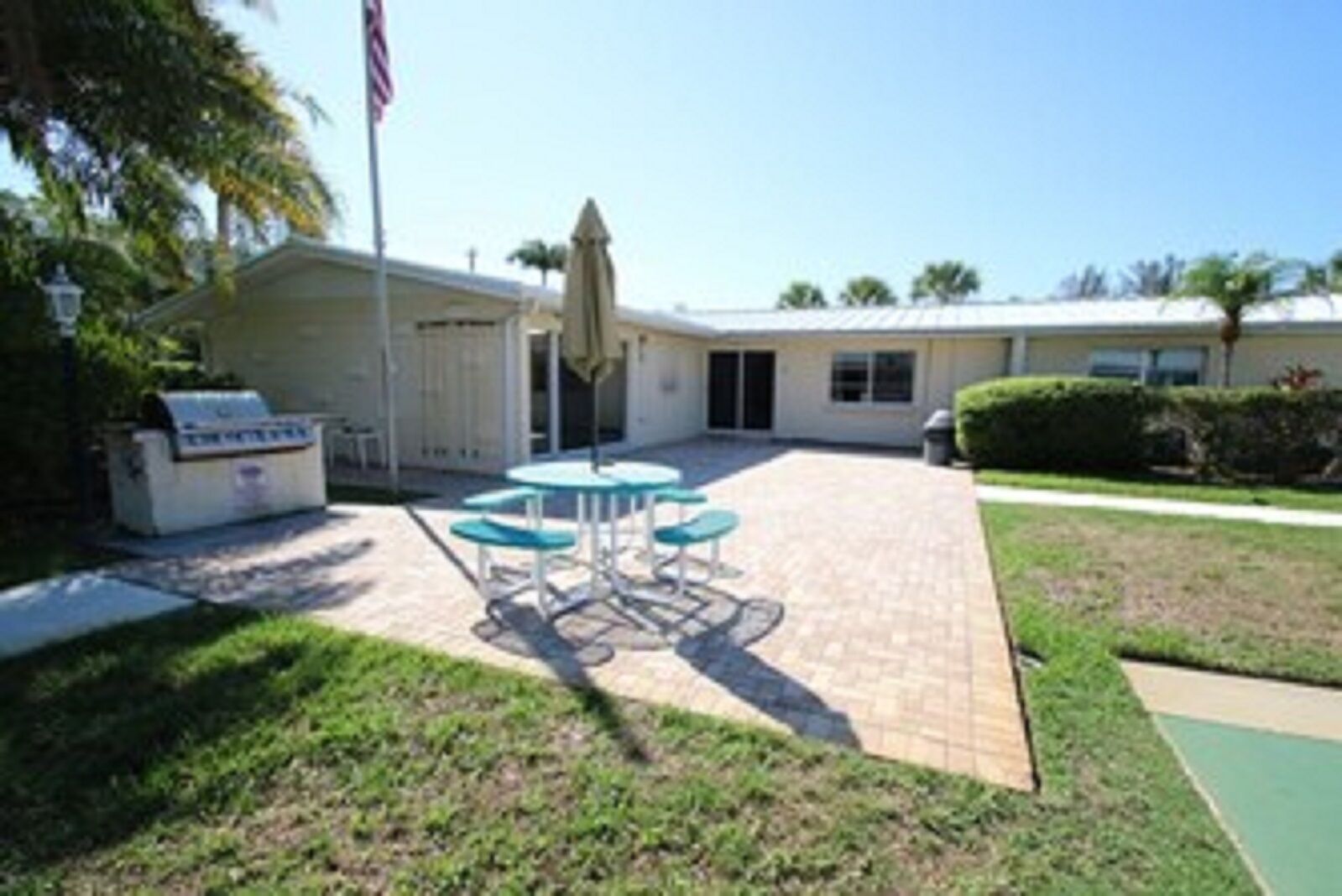 A patio area with a grill, outdoor table and chairs, and a covered seating area.
