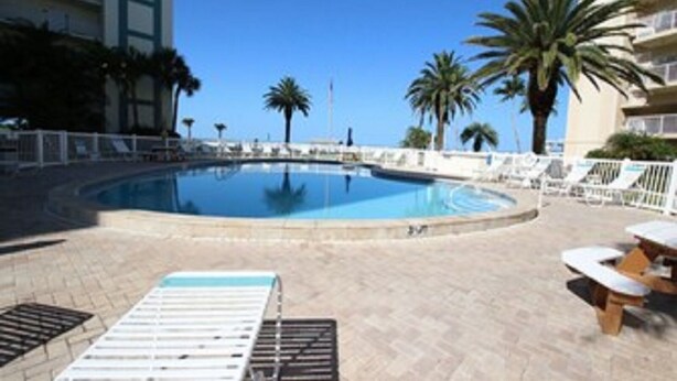 A swimming pool with lounge chairs and palm trees. - Jamaica Royale Siesta Key Condo 109 (Siesta Key)