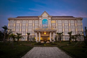 Vista frontal de la propiedad por la tarde o noche