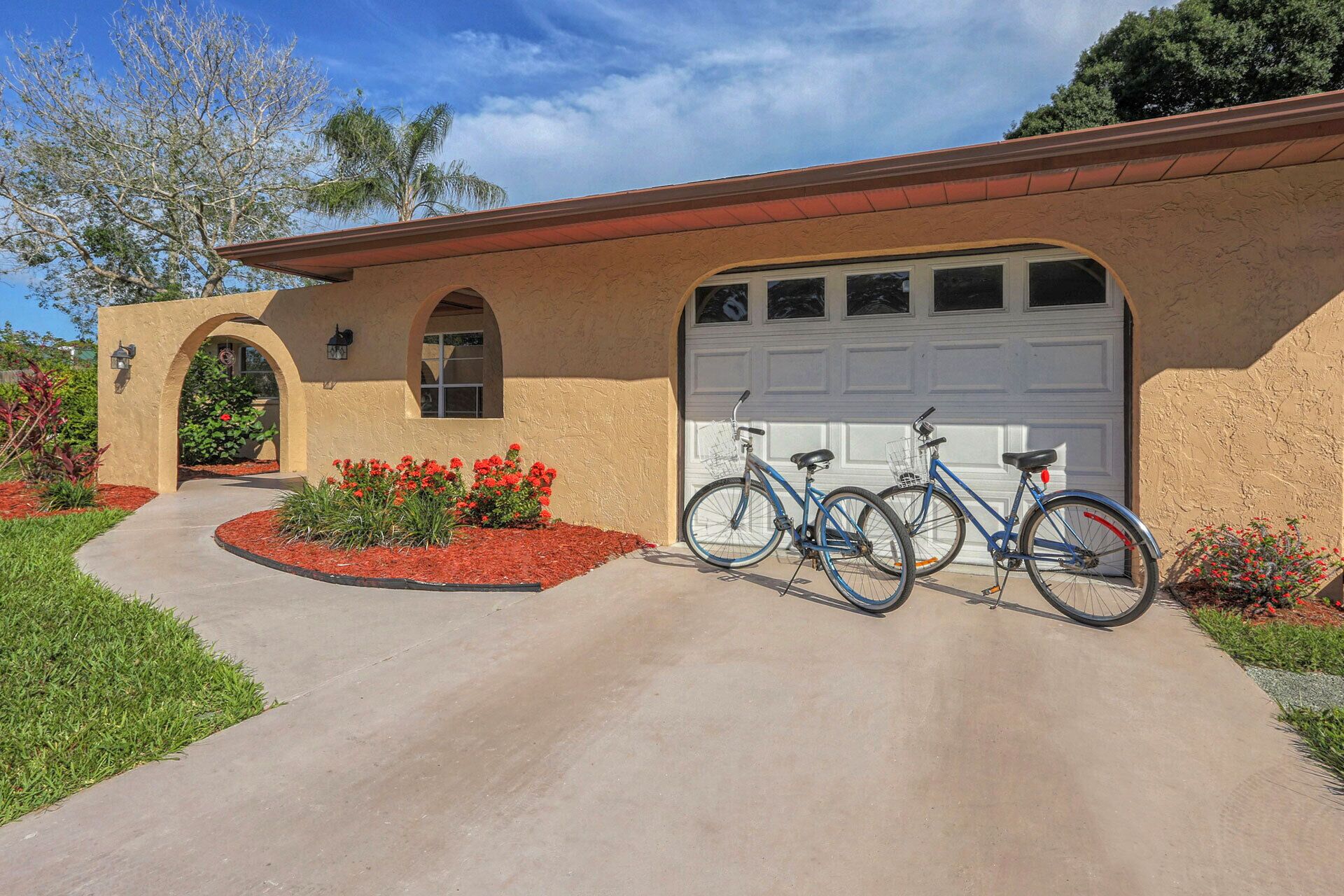 A house with a garage, a driveway, and two bicycles parked in front.