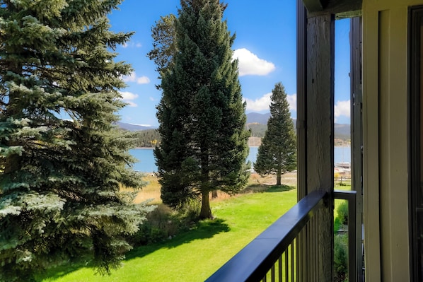 A balcony with a view of a lake, trees, and mountains in the distance. - 2BR Lake Dillon Escape w/ Pool & Hot Tub! (Dillon)