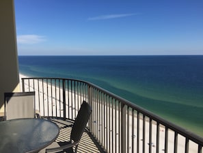 Un balcon avec vue sur l’océan, une table et une chaise.