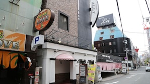 Un hôtel avec une enseigne indiquant « Hôtel Ally Lei » et un panneau indiquant un parking.
