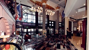 A lobby with a checkered floor, a glass coffee station, and a staircase with a railing. - Harbin Bremen Jewish Culture Theme Hotel (Harbin)