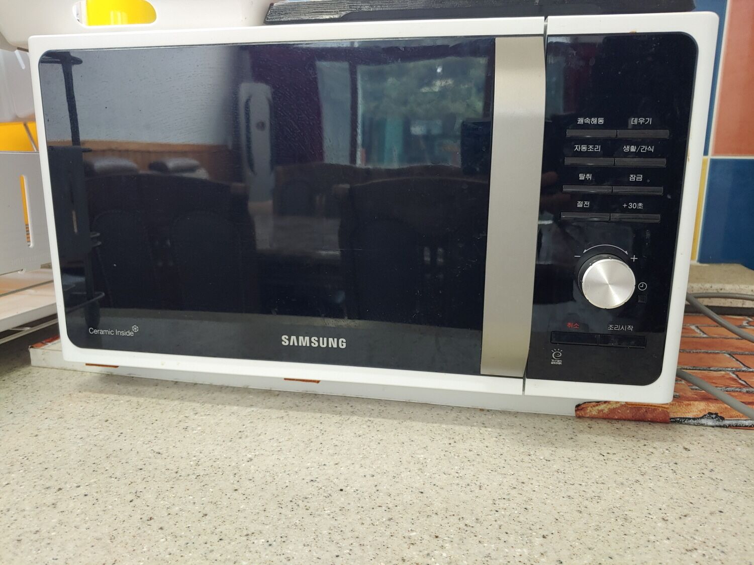A white microwave oven with a black control panel and a glass door.