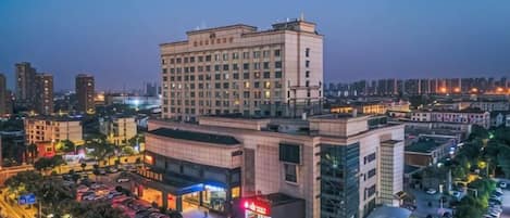 A multi-story hotel with a parking lot in front.