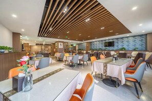 Een modern restaurant met meerdere eettafels, stoelen en een plafond met houten latten.