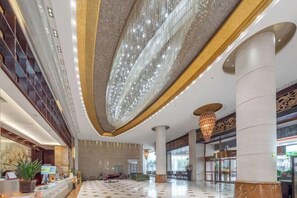 A spacious lobby with a high ceiling, large columns, and a chandelier. - Meigaomei International Hotel (Kunshan Lujia) (Kunshan)