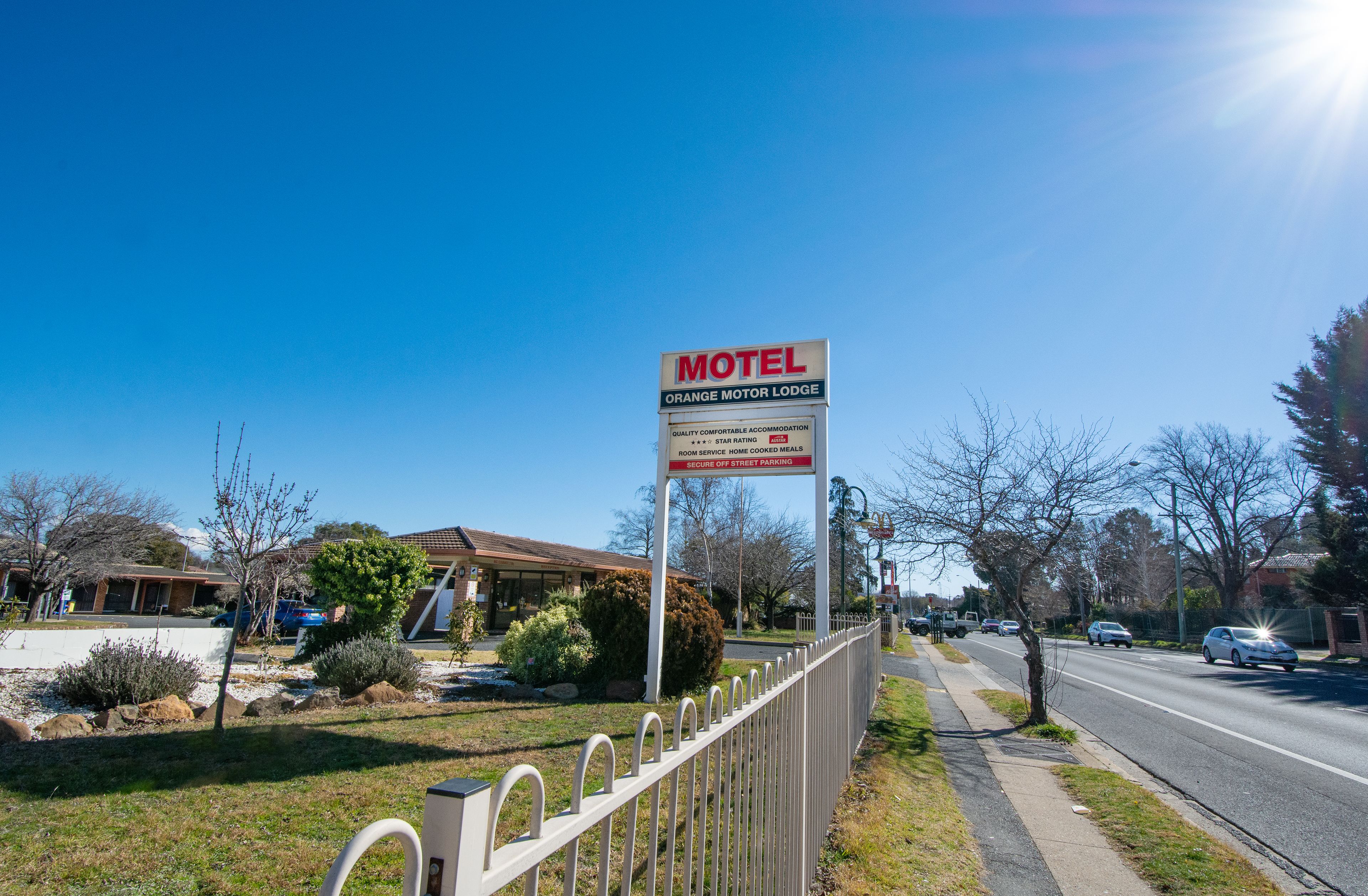 Señal de motel con vista clara del estacionamiento y la carretera.