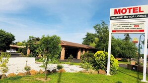 A motel named Orange Motor Lodge with a signboard advertising quality accommodation, room service, home cooked meals, and secure off-street parking. - Orange Motor Lodge (Orange)