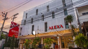 A building with the sign "ALEXA" and a large red sign for "ALEXA Sleep & Relaxation Bangkok". - ALEXA Nimman - Hostel (Chiang Mai)