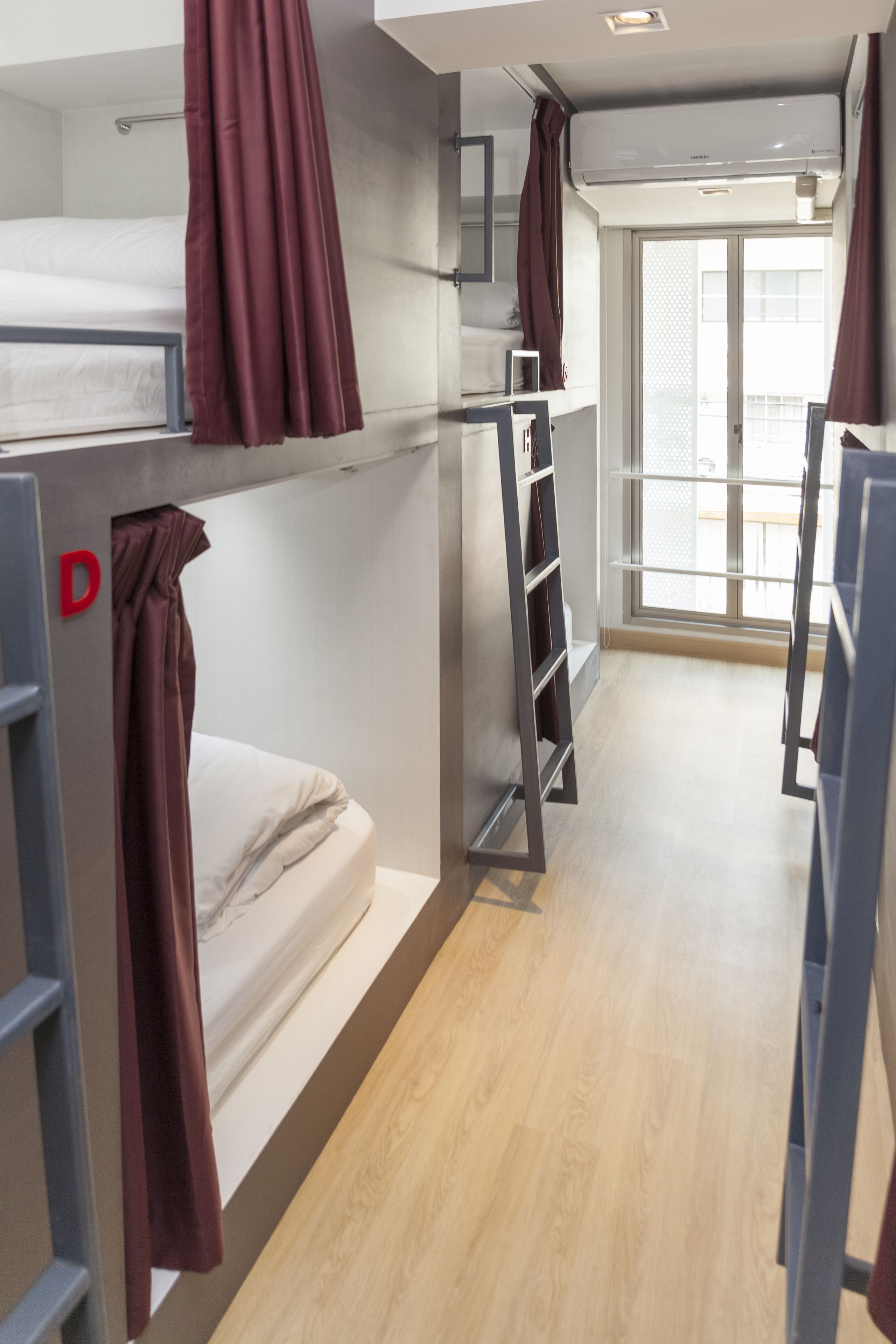 Ein Schlafsaalzimmer mit Etagenbetten, einem Kleiderschrank und einem Fenster mit Blick.