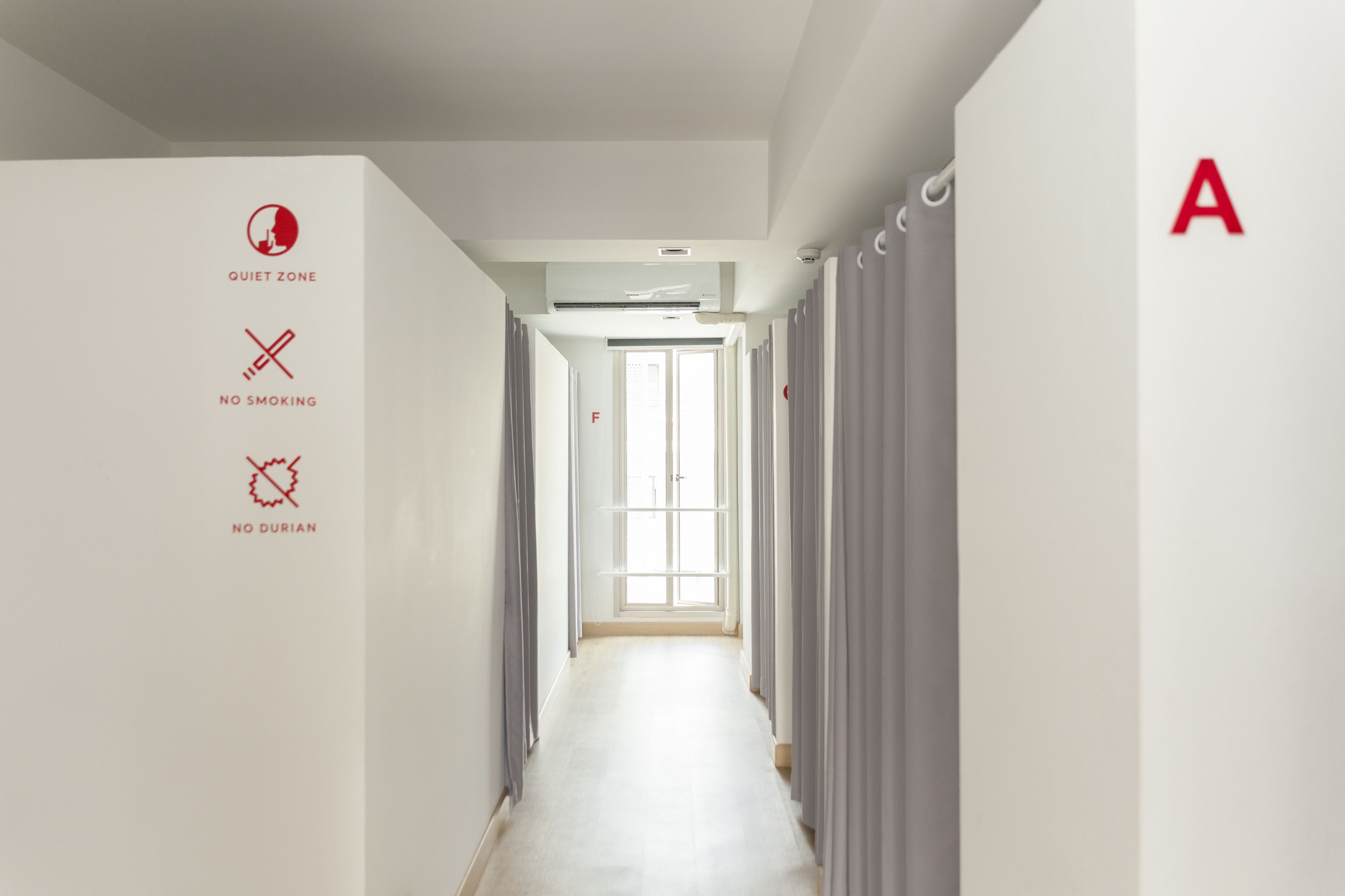 A hallway with a sign indicating a quiet zone, no smoking, and no durian.