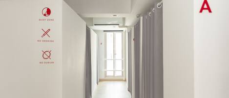 A hallway with a sign indicating a quiet zone, no smoking, and no durian.