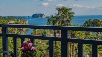 Una vista costiera con una palma e una piccola isola all'orizzonte.