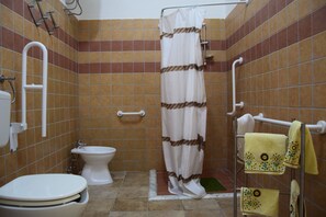 Vierpersoonskamer | Badkamer | Een douche, gratis toiletartikelen, een haardroger, een bidet