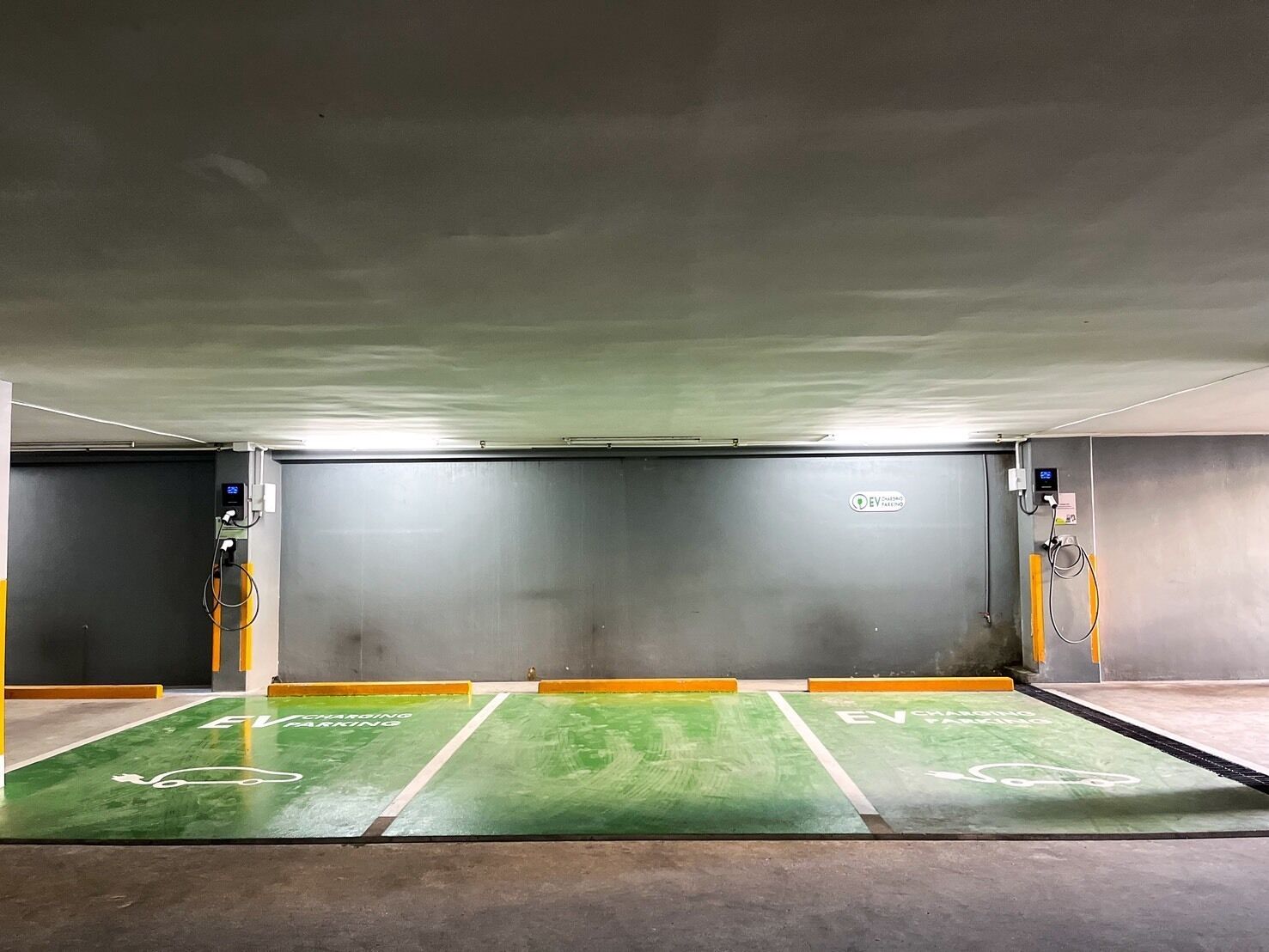 An underground parking garage with EV charging stations and designated EV parking spaces.
