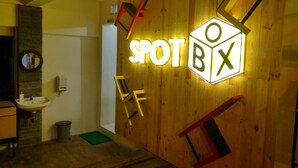 A wooden wall with a neon sign reading "SPOT BOX". - Front One Inn Semarang (Semarang)