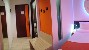 A hotel room with two beds, a small desk with a chair, and a window with a view. - Front One Inn Semarang (Semarang)