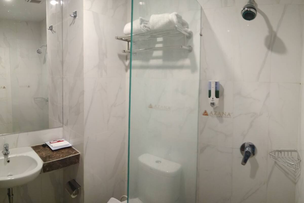 A modern bathroom with a glass shower enclosure, a sink, and a toilet.