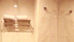 A bathroom with a toilet, sink, and towel rack. - Front One Inn Semarang (Semarang)