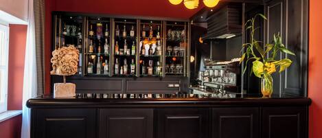 A bar area with a dark wood cabinet, a decorative sculpture, and a vase with yellow flowers.