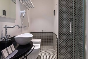Un bagno moderno con un lavandino capiente, il water e una doccia.