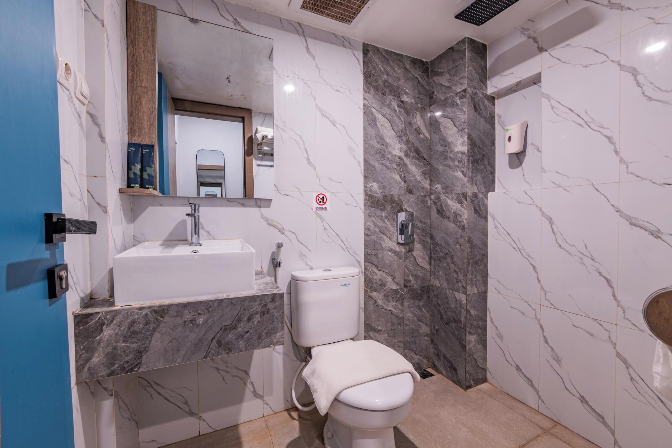 A bathroom with a sink, toilet, and mirror.