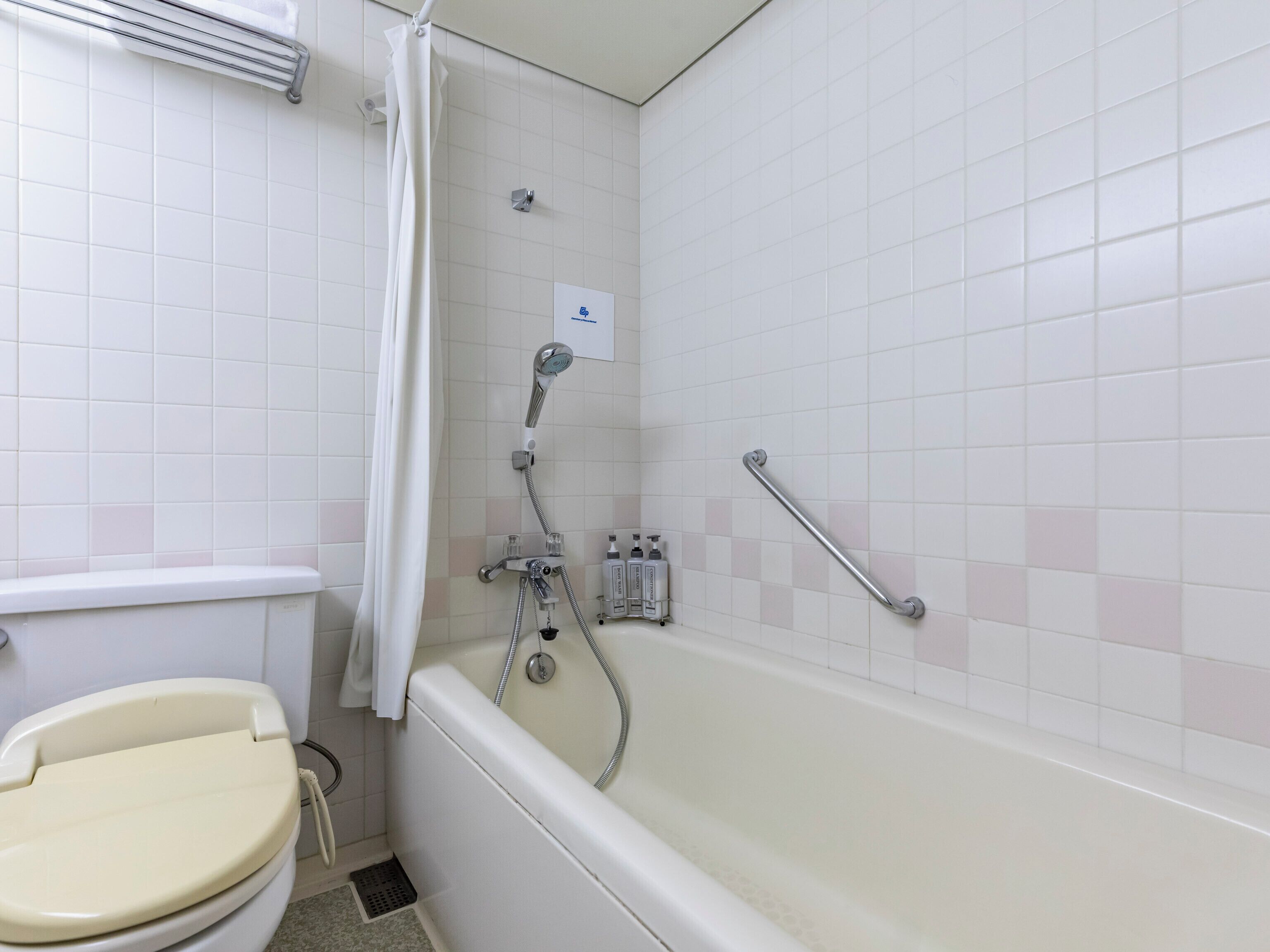 A bathroom with a toilet, a bathtub, and a shower.