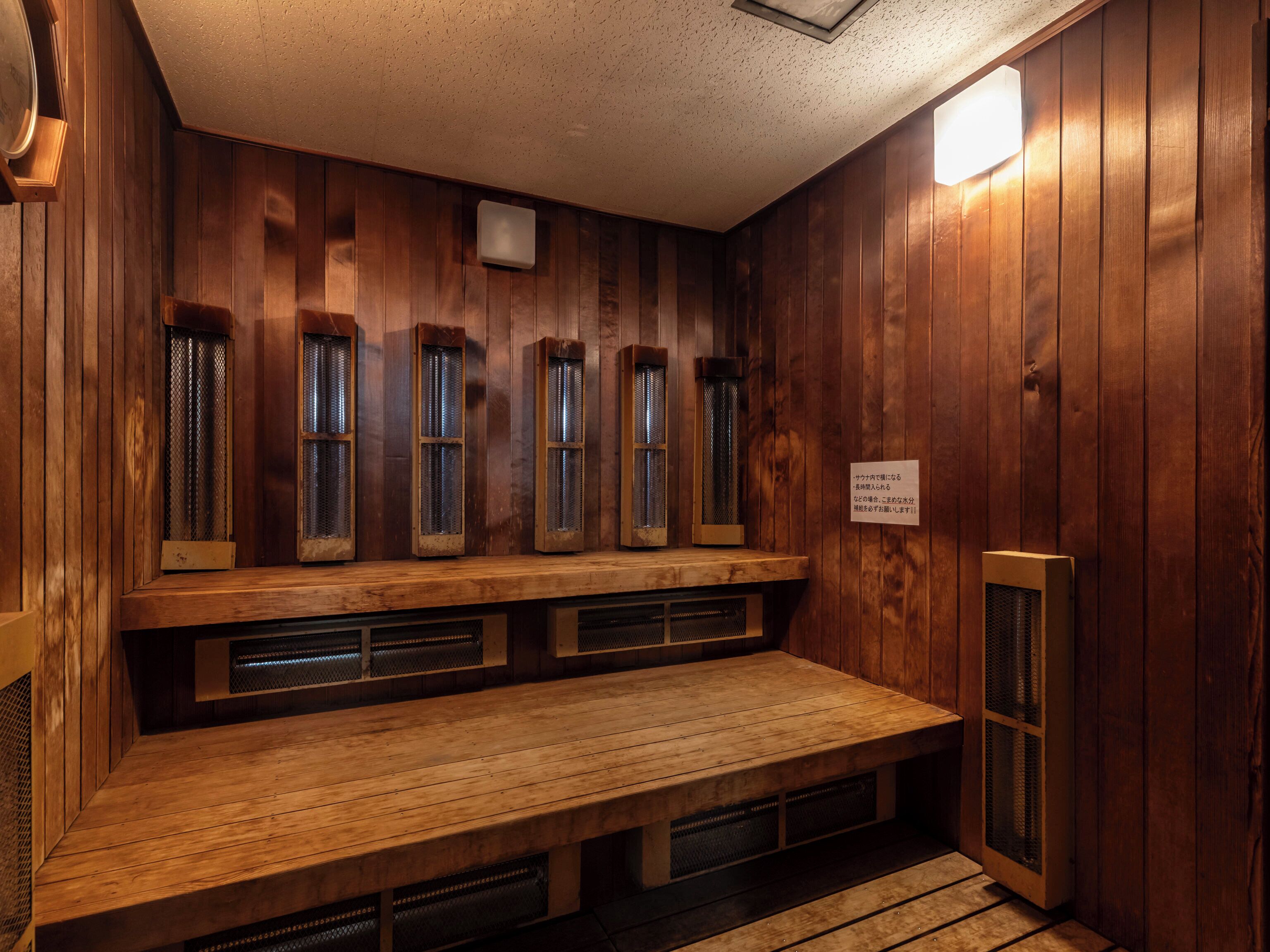 A sauna room with wooden walls and benches.