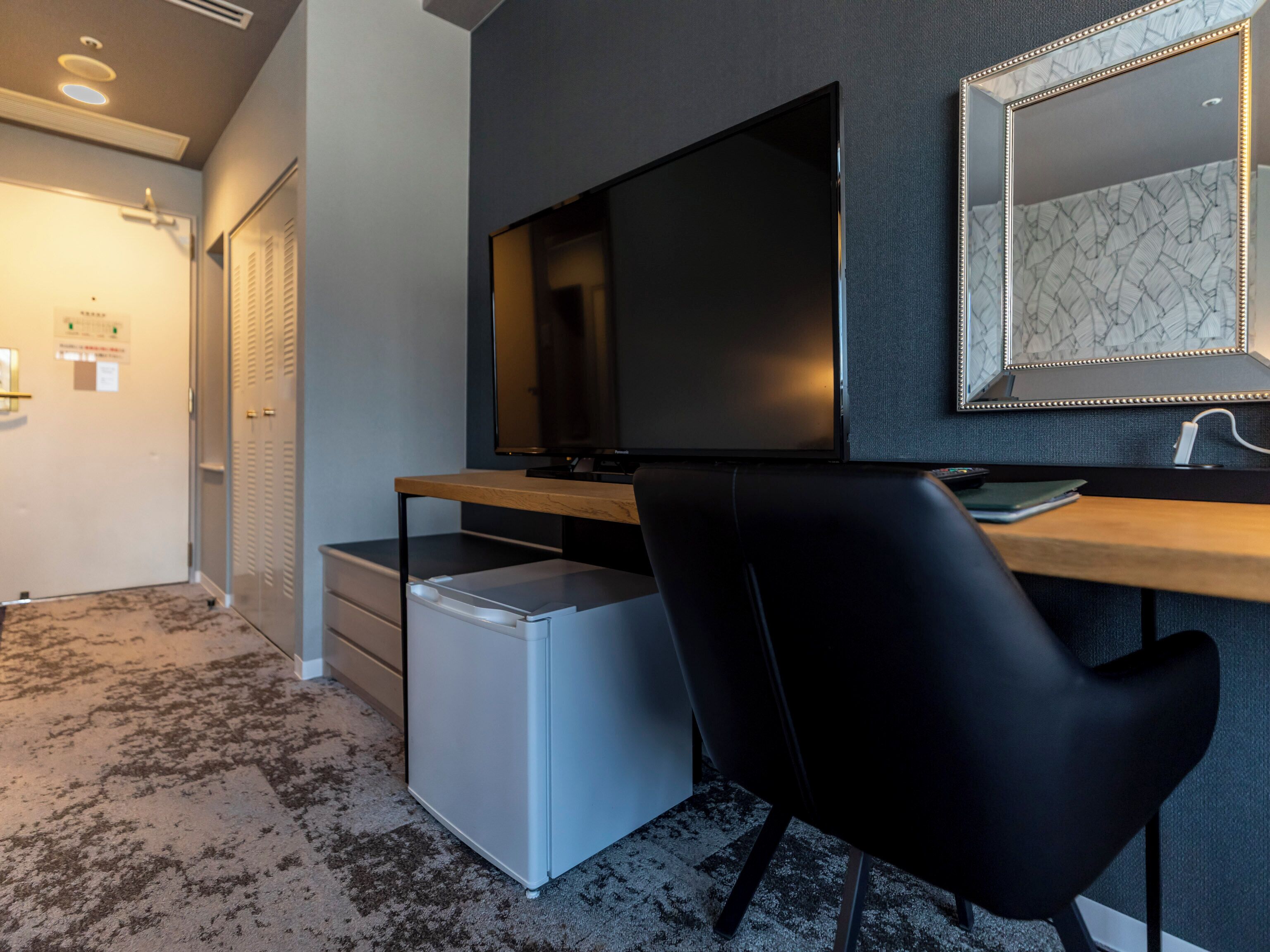 A modern bedroom with a bed, a desk, and a chair.