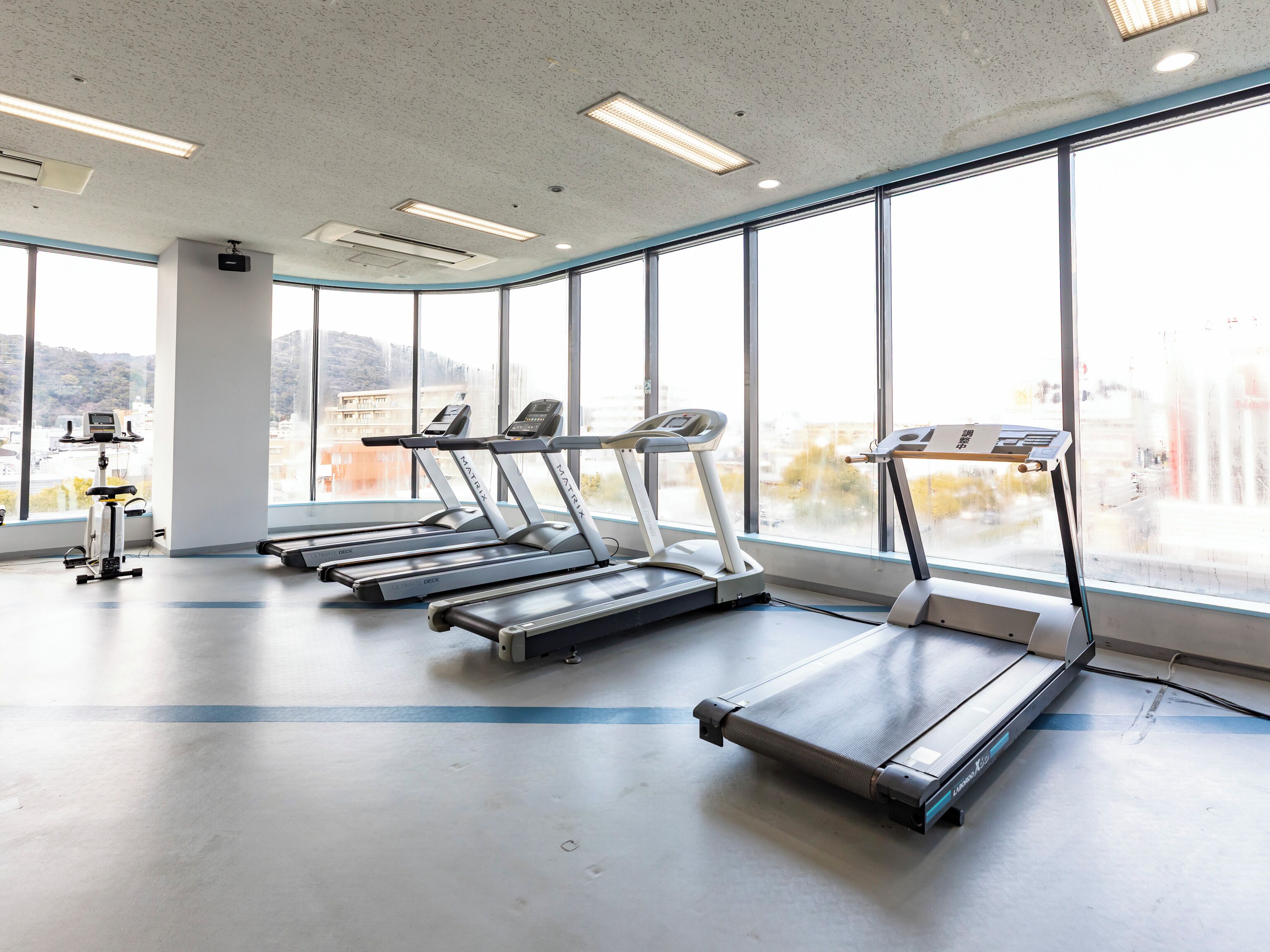 Une salle de sport équipée de tapis de course, d’un vélo d’appartement et d’un appareil d’aviron.