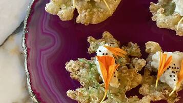 Un plato de aperitivos con un borde decorativo, sobre una superficie de mármol.