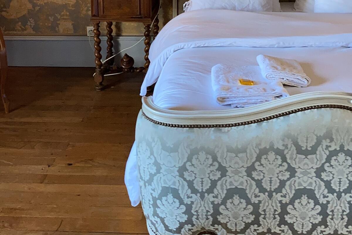 Un dormitorio con cama, mesita de noche y lámpara.