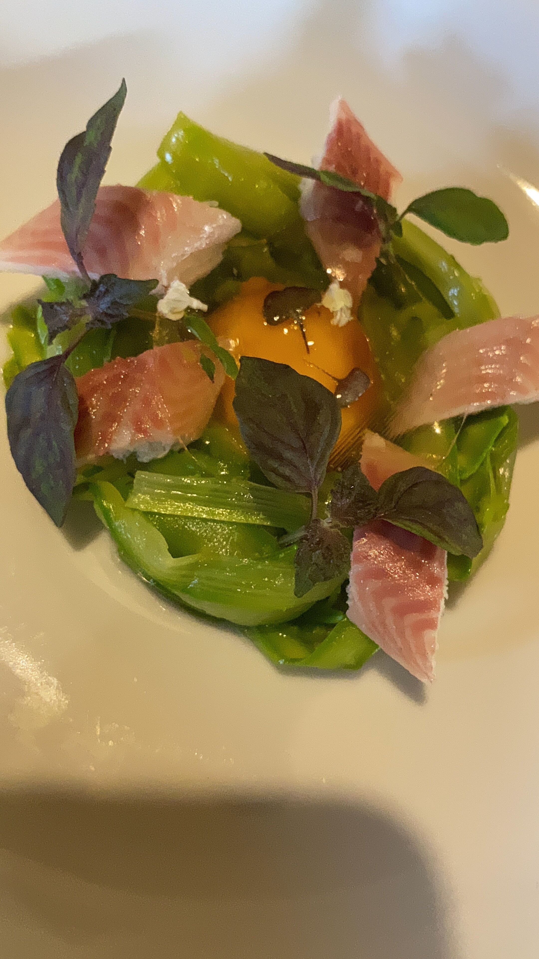 A plate of food with greens, egg, and meat.