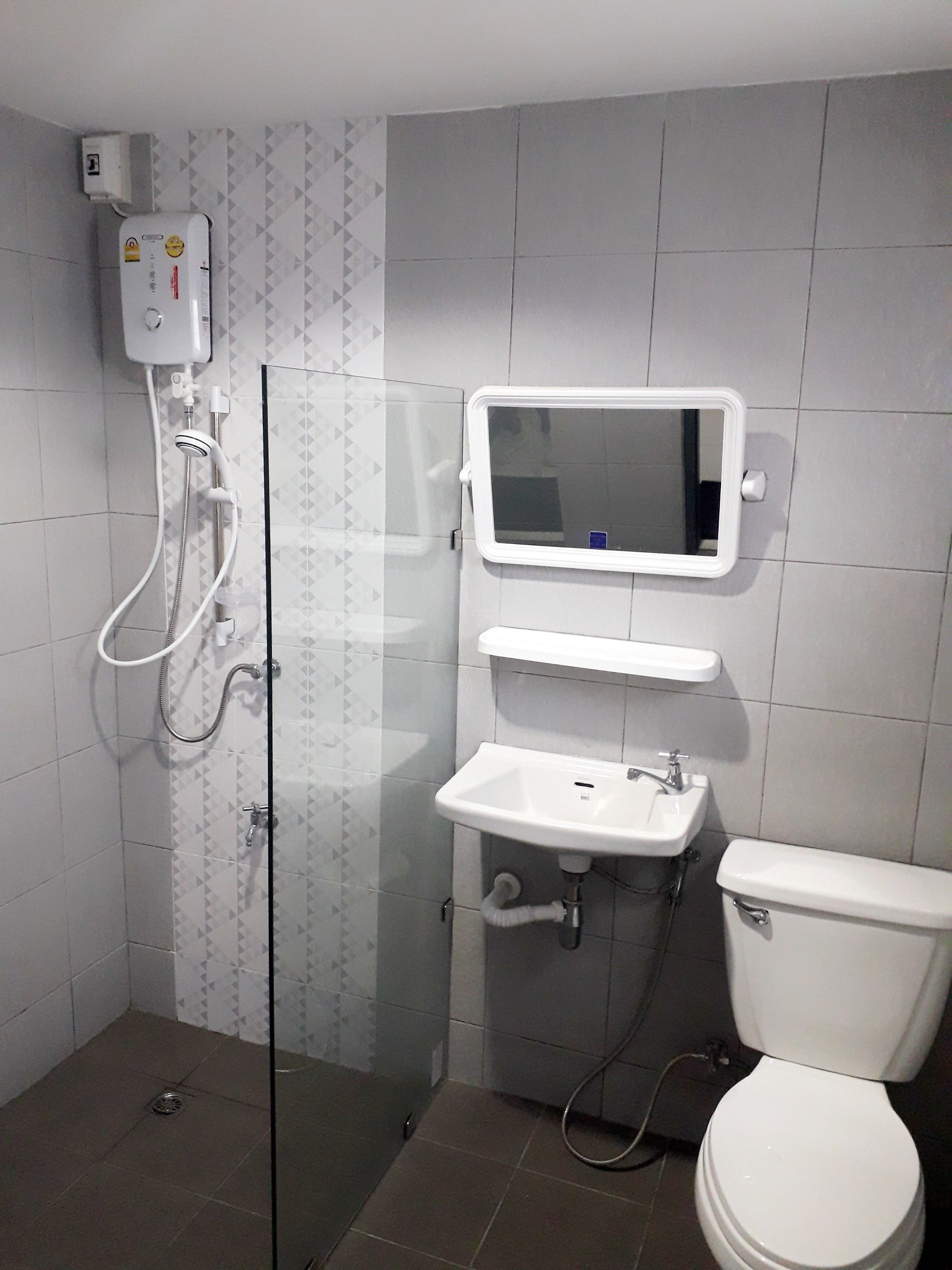 A bathroom with a glass-enclosed shower, a white sink, and a toilet.