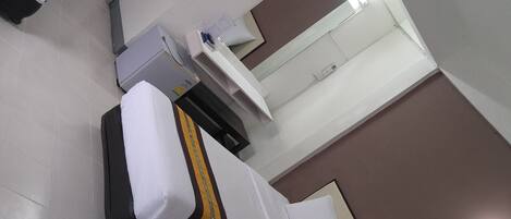 A hotel room with two beds, a bathroom, and a window.