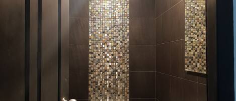 Un baño con inodoro, lavabo y paredes de azulejos.