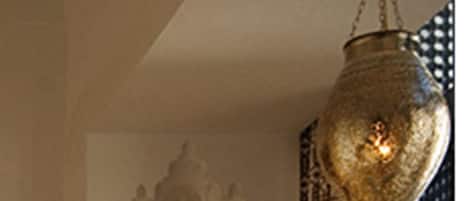 A room with a circular wall light fixture and a hanging lantern.