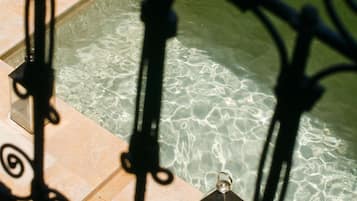 Una piscina al aire libre, sombrillas, tumbonas