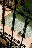 Una piscina al aire libre, sombrillas, sillones reclinables de piscina