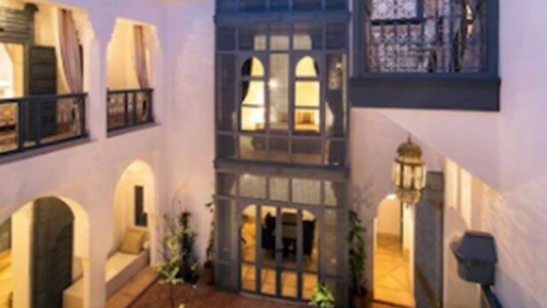 A courtyard with a fountain, arches, and a building with balconies and windows. - Riad Adore (Marrakech)