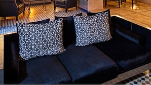 A modern interior with a sofa set, a dining area, and decorative lighting. - Riad Adore (Marrakech)